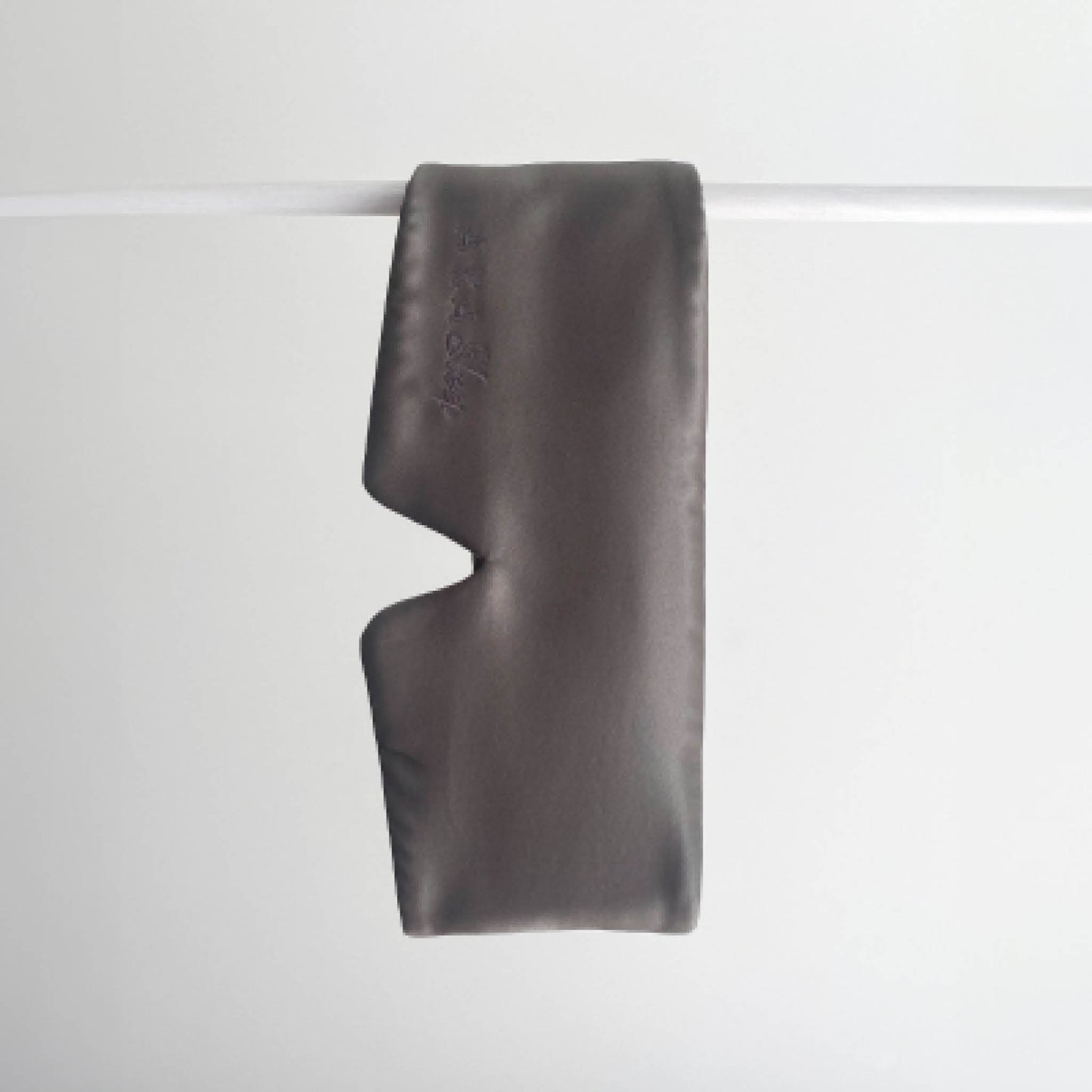 Slate Charcoal 100% Mulberry Silk Deep Sleep Eye Maks handing on a white rod with a white background