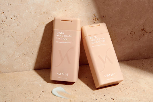 Two Van-it shampoo bottles on a beige background